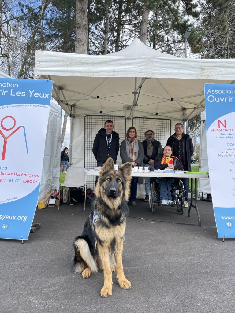 Photo de l'équipe d'OLY derrière le stand de sensibilisation. De gauche à droite : David, Maryse, Stéphane, Mathieu, Thierry.

Devant le stand se trouve le chien Texas.